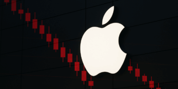 Fachada con logo iluminado de Apple y velas bursátiles rojas apple