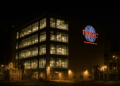 Fachada iluminada de la planta TSMC en Taiwán por la noche, reflejando actividad operativa intensa