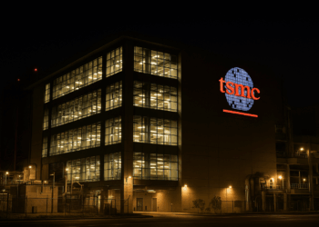 Fachada iluminada de la planta TSMC en Taiwán por la noche, reflejando actividad operativa intensa