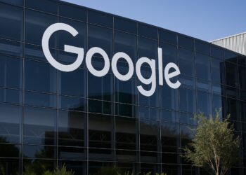 Fachada de un edificio de Alphabet con logo visible en ángulo realista.