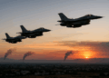 Tres aviones de combate de israel F-16 vuelan al atardecer sobre Damasco con columnas de humo al fondo