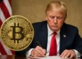 Donald Trump frente a una mesa con una gran moneda de Bitcoin en primer plano en contexto institucional.