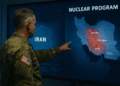 Un militar estadounidense señala un mapa de Irán con sitios clave del programa nuclear en una pantalla de inteligencia