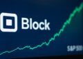 Pantalla bursátil muestra el logo de Block, un gráfico ascendente y el índice S&P 500 al costado.