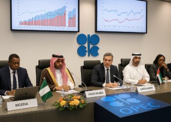 Delegados de la OPEC en sala de conferencias con gráficos de producción petrolera proyectados.