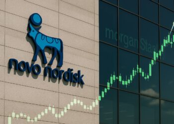 Fachada de la sede de Novo Nordisk con su logotipo visible y gráficos financieros ascendentes proyectados.