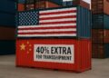 Contenedores apilados con banderas de EE.UU. y China y letrero que indica “40% extra por transbordo”.