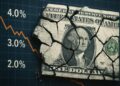 Montaje con billete de dólar roto sobre gráfico de tasas de interés descendente