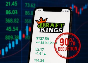 Smartphone con app de DraftKings y sello rojo de “90% deduction” sobre cifras verdes.