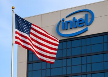 Intel con sede corporativa y bandera de Estados Unidos ondeando al frente, reflejando la posible participación del gobierno.