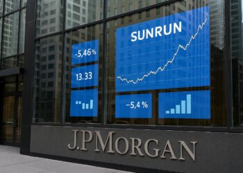 Fachada de JPMorgan en Nueva York con pantallas que muestran gráficos de Sunrun