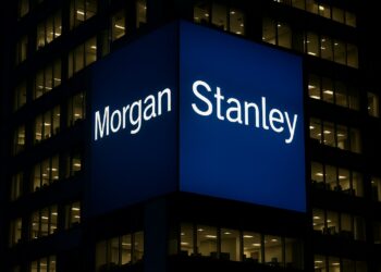 Edificio de Morgan Stanley en Nueva York con logo azul iluminado de noche y oficinas encendidas