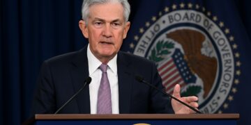 Jerome Powell durante un discurso en un podio con el sello de la Reserva Federal al fondo.