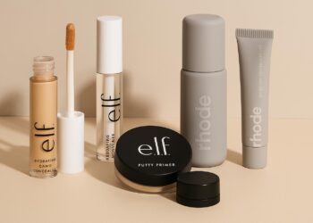 Productos de E.l.f. y Rhode alineados sobre fondo beige con iluminación suave