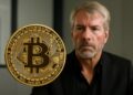 Bitcoin en primer plano con Saylor al fondo, ambiente de oficina, composición horizontal realista.