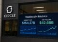 Fachada de la sede de Circle con pantalla que proyecta métricas y gráficos de stablecoins