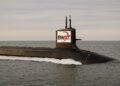 Submarino nuclear navegando en mar abierto con logo de BWXT visible en la torre