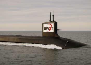 Submarino nuclear navegando en mar abierto con logo de BWXT visible en la torre