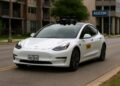 Un Tesla Model 3 autónomo convertido en robo-taxi circula en Austin, mostrando el enfoque tecnológico de cámaras ópticas.