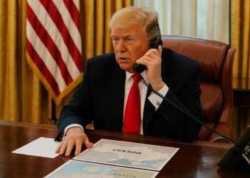 Trump en el Despacho Oval hablando por teléfono con mapas de Ucrania y Rusia sobre el escritorio.