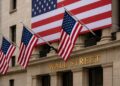 Fachada de Wall Street con banderas de EE. UU., reflejando crecimiento del PIB.