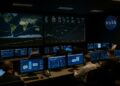 Imagen editorial muestra el centro de control de NASA con ingenieros y pantallas exhibiendo trayectorias de sondas espaciales