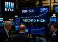 Fotografía editorial muestra el piso de la Bolsa de Nueva York con pantallas destacando al S&P 500 en niveles récord