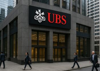 Vista de la fachada de UBS en un distrito financiero con logo rojo destacado sobre el edificio