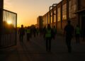 Trabajadores saliendo de una fábrica al atardecer, reflejando el enfriamiento del mercado laboral en EE.UU.