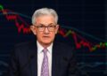 Jerome Powell durante una conferencia de prensa con gráficos de mercado proyectados detrás