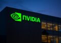 Edificio corporativo de Nvidia al anochecer con logotipo verde iluminado en la fachada
