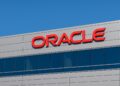  Vista del logo de Oracle en la fachada de un edificio corporativo con cielo azul despejado