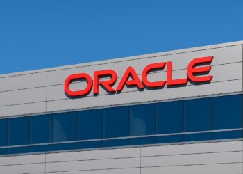  Vista del logo de Oracle en la fachada de un edificio corporativo con cielo azul despejado