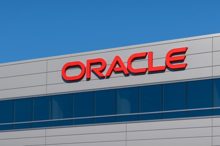Vista del logo de Oracle en la fachada de un edificio corporativo con cielo azul despejado