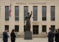 Fachada de tribunal federal en Washington con estatua de la justicia y bandera estadounidense