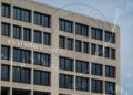 Fachada del U.S. Department of Labor con sello difuminado y gráficos financieros superpuestos