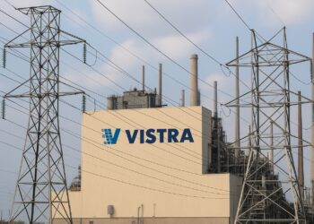 Planta eléctrica de Vistra con su logo visible y torres de transmisión con cables de energía