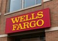 Fachada de un edificio bancario con el letrero rojo y amarillo de Wells Fargo en primer plano