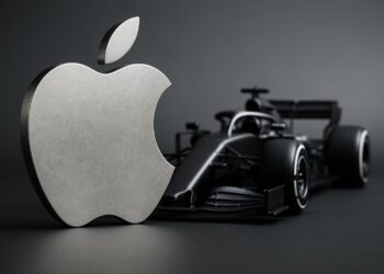 Logo metálico de Apple frente a un monoplaza de Fórmula 1 bajo luz natural de estudio.