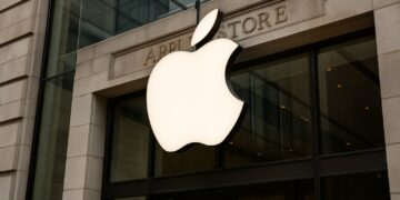 Fachada de Apple Store en EE. UU. con el logo de Apple iluminado sobre la entrada