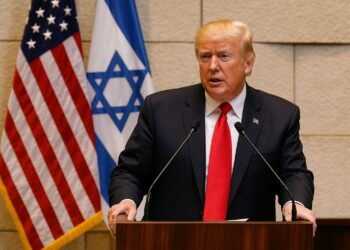 Donald Trump en el Parlamento israelí hablando frente a micrófonos con las banderas de Estados Unidos e Israel al fondo.