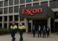 Fachada de la sede de Exxon con logo visible y trabajadores en uniforme y traje saliendo del edificio