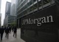Edificio de JPMorgan en un distrito financiero con logo visible y peatones caminando entre rascacielos