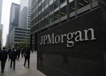 Edificio de JPMorgan en un distrito financiero con logo visible y peatones caminando entre rascacielos