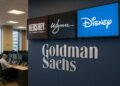 Interior de las oficinas de Goldman Sachs con pantallas digitales que muestran los logotipos de Hershey, Wynn y Disney.