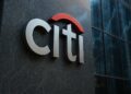 Logo tridimensional de Citi en fachada corporativa con detalles de IA y reflejos bursátiles.