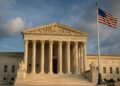 Fachada de la Corte Suprema de Estados Unidos con bandera nacional ondeando al frente.