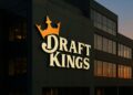 Logo de DraftKings iluminado en la fachada principal del edificio corporativo al anochecer.