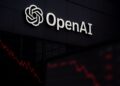 Logo de OpenAI iluminado en fachada con líneas rojas descendentes reflejadas en vidrio