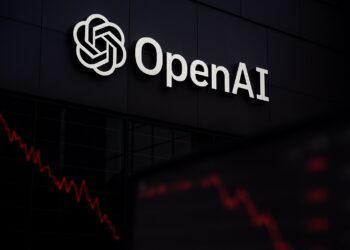 Logo de OpenAI iluminado en fachada con líneas rojas descendentes reflejadas en vidrio
